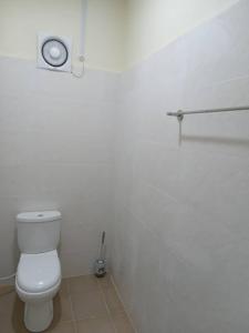 a bathroom with a white toilet in a room at OceanBoys Chalet Coral Bay in Kampong Pasir Panjang