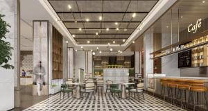 a restaurant with tables and chairs and a bar at Elong Hotel Jakarta PIK in Jakarta
