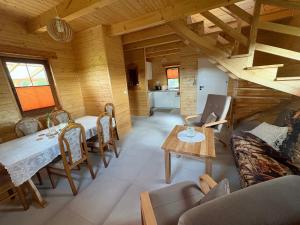 a living room with a table and chairs in a cabin at Bociani Zakątek nad jeziorem in Leszczewo