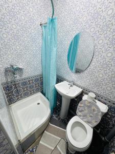 ein Badezimmer mit Waschbecken, Toilette und Spiegel in der Unterkunft Uncle Kolya Hotel str M Azam 39 in Buxoro + 31 Fotos