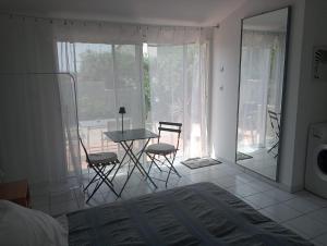a bedroom with a bed and a table and chairs at Chambre Indépendante sur terrain avec piscine in Ollières