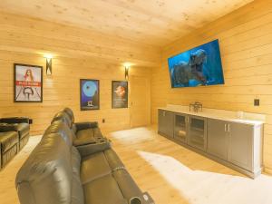 a living room with a couch and a flat screen tv at Smoky Ridge Sanctuary in Sevierville