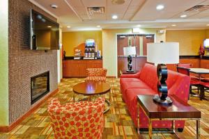 a living room with a red couch and a fireplace at Holiday Inn Express Hotel & Suites Memphis/Germantown by IHG in Memphis