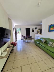 sala de estar con sofá verde y TV de pantalla plana en Sunny Home Herradura - Family & Work From Beach, en Herradura