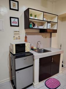 a small kitchen with a sink and a microwave at Jhohanna's Cozy Corners in Iruhin