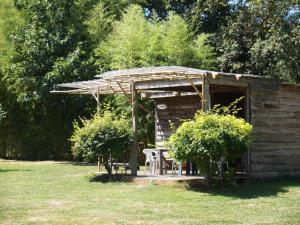 Noyal-Muzillacにあるcamping chez l'habitantの畑にあるテーブルと椅子のある木造の小屋