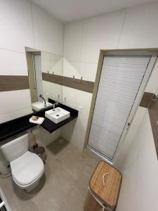 a bathroom with a toilet and a sink and a mirror at Triplex Dunas - Flecheiras in Trairi +26 photos