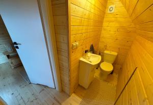 a wooden bathroom with a toilet and a sink at Bociani Zakątek nad jeziorem in Leszczewo +26 photos