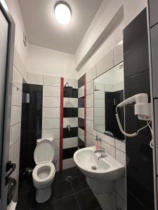 a bathroom with a white toilet and a sink at Hotel Aulona in Fier