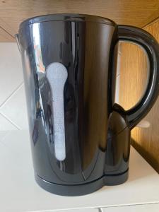 ロッツァーノにあるLa Maison di Grace vicino Humanitas & Forumのリモコンが入った黒いコーヒーカップ