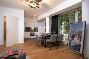 a kitchen and dining room with a table and chairs at Brand new luxury apartment on Rathausplatz in Augsburg