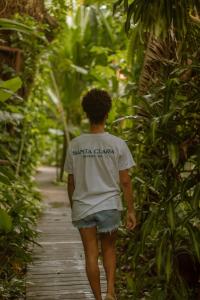 a boy walking down a path in a forest at Pousada Santa Clara in Ilha de Boipeba +41 photos