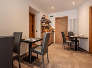 a dining room with four tables and chairs at Le Crode Bed and Breakfast in Auronzo di Cadore
