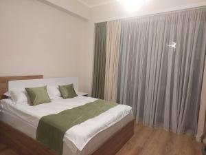 a bedroom with a bed with green and white sheets at Host House Tsaghkadzor 59 in Tsaghkadzor