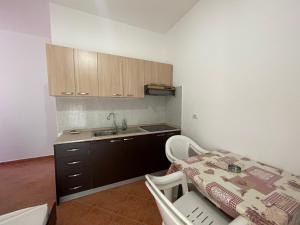 a kitchen with a table and a sink and a counter at Rajan Rooms in Vlorë
