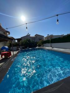 a swimming pool with blue water in a backyard at Rajan Rooms in Vlorë