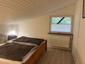 a bedroom with a bed in a room with a window at Taylors Allerhaus in Hornbostel