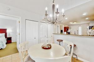 een witte eetkamer met een witte tafel en stoelen bij Sunset Vistas Condo 203S in St Pete Beach +17 foto's