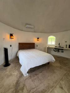 a bedroom with a large bed and a window at El bungalito de chuburna in Mérida