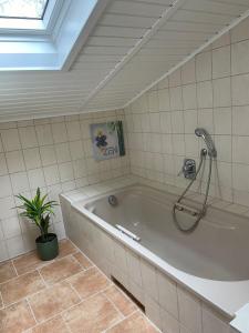 a bath tub with a shower in a bathroom at Taylors Allerhaus in Hornbostel +50 photos