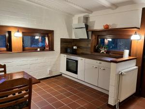 a kitchen with white appliances and a table and a table and a table at Taylors Allerhaus in Hornbostel