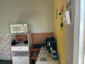 a small room with a bed and a microwave at Viver a paz, praia & home office rua Nelson Pecegueiro do Amaral, 267, costa azul in Rio das Ostras