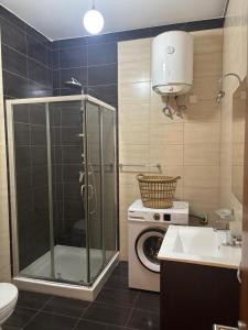 a bathroom with a shower and a washing machine at Sorrento in St. Julianʼs +22 photos