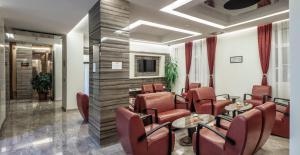uma sala de espera com cadeiras, mesas e uma TV em Theater Hotel Belgrade em Belgrado