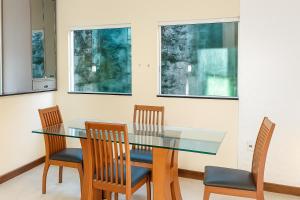 a dining room with a glass table and chairs at Casa em Jauá in Camaçari