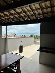 a view of a balcony with a table and a luggageenser at Triplex Dunas - Flecheiras in Trairi