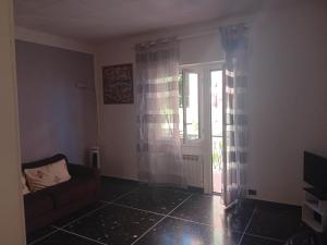 a living room with a couch and a sliding glass door at Appartamento a Sampierdarena in Genoa