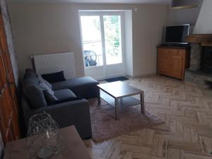 a living room with a couch and a coffee table at Gîtes du Café de la poste in Le Buisson