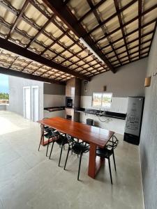 a large kitchen with a wooden table and chairs at Triplex Dunas - Flecheiras in Trairi