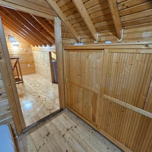 a wooden garage with wooden doors and a wooden floor at Magic Cottage From Paradise in Râu de Mori +27 photos