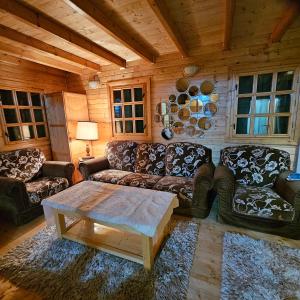 a living room with couches and a coffee table at Magic Cottage From Paradise in Râu de Mori