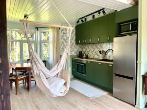 a kitchen with a hammock in a kitchen with green cabinets at Villa Keerberg in Taevaskoja