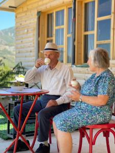 an older man and woman sitting at a table eating ice cream at Xhagolands in Përmet