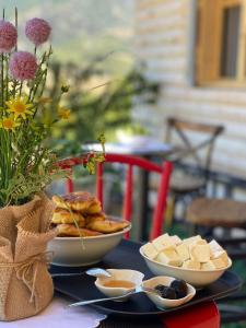 a table with two bowls of cheese and bread on it at Xhagolands in Përmet