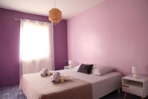 a bedroom with two beds with purple walls and a window at La Villa Noyau Doux in Ampuis