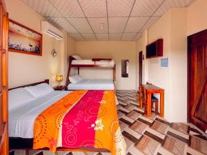 a bedroom with two bunk beds and a desk at Hostal Laurita Beach in Montañita
