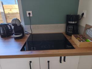 a kitchen counter with a black stove top oven at Gite de la perle rouge 1 Chambre 2-4 personnes in Rodelinghem +28 photos