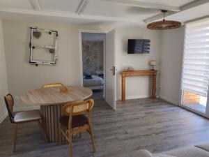 a dining room with a table and chairs and a mirror at Gite de la perle rouge 1 Chambre 2-4 personnes in Rodelinghem