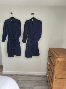 two blue robes hanging on a wall next to a dresser at Gite de la perle rouge 1 Chambre 2-4 personnes in Rodelinghem