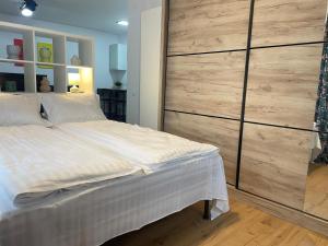 ein Schlafzimmer mit einem großen Bett und einer großen Holzwand in der Unterkunft Apartament Corvin 2 in Hunedoara