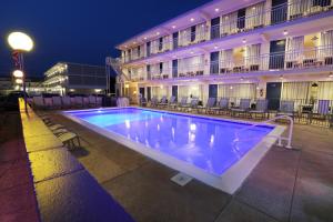 a swimming pool in front of a hotel at night at Lark Motel in Stone Harbor