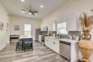 a large kitchen with white cabinets and a table at Steps to Seawall Spacious Condo in Galveston! in Galveston