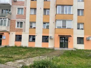 ein Apartmenthaus mit einem Grasfeld davor in der Unterkunft Apartament Corvin 2 in Hunedoara