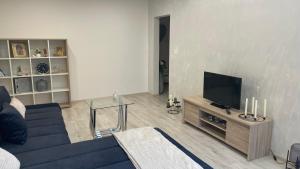 a living room with a blue couch and a television at Apartman Chill day in Michalovce