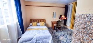 ein kleines Schlafzimmer mit einem Bett und einem Tisch in der Unterkunft Victoria Palace in Chuka + 12 Fotos