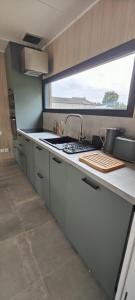 a kitchen with a sink and a stove and a window at La Cabane du Gouët in Saint-Julien